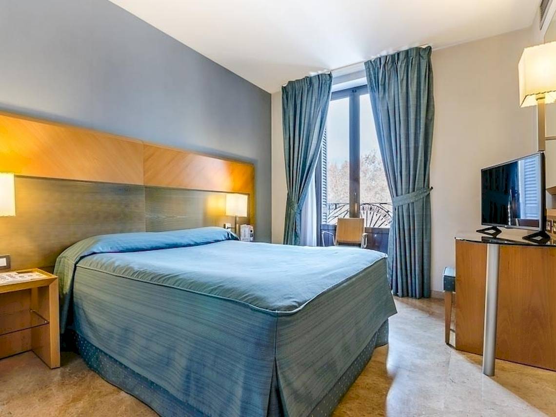 Hotelzimmer im Del Mar Barcelona mit Bett, Fernseher und Fenstern.