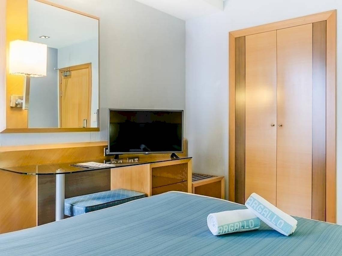 Hotelzimmer im Del Mar Hotel in Barcelona mit Fernseher, Schreibtisch und Schränken