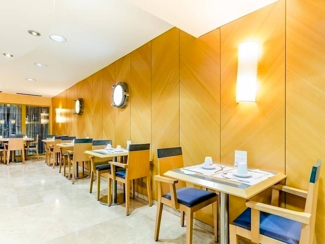 Frühstücksraum im Del Mar - Barcelona Hotel mit hölzernen Wänden und Tischen