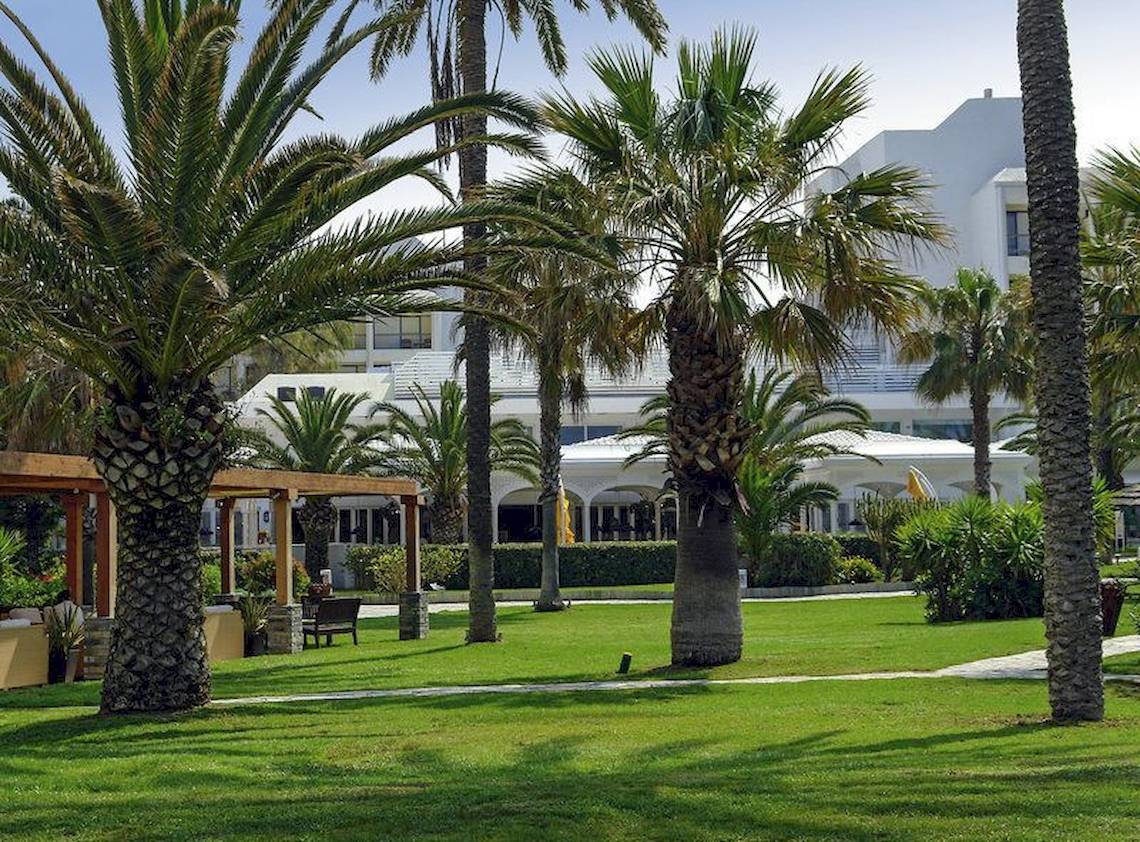 Vorgarten des Robinson Kyllini Beach Hotels mit Palmen und Gebäude im Hintergrund
