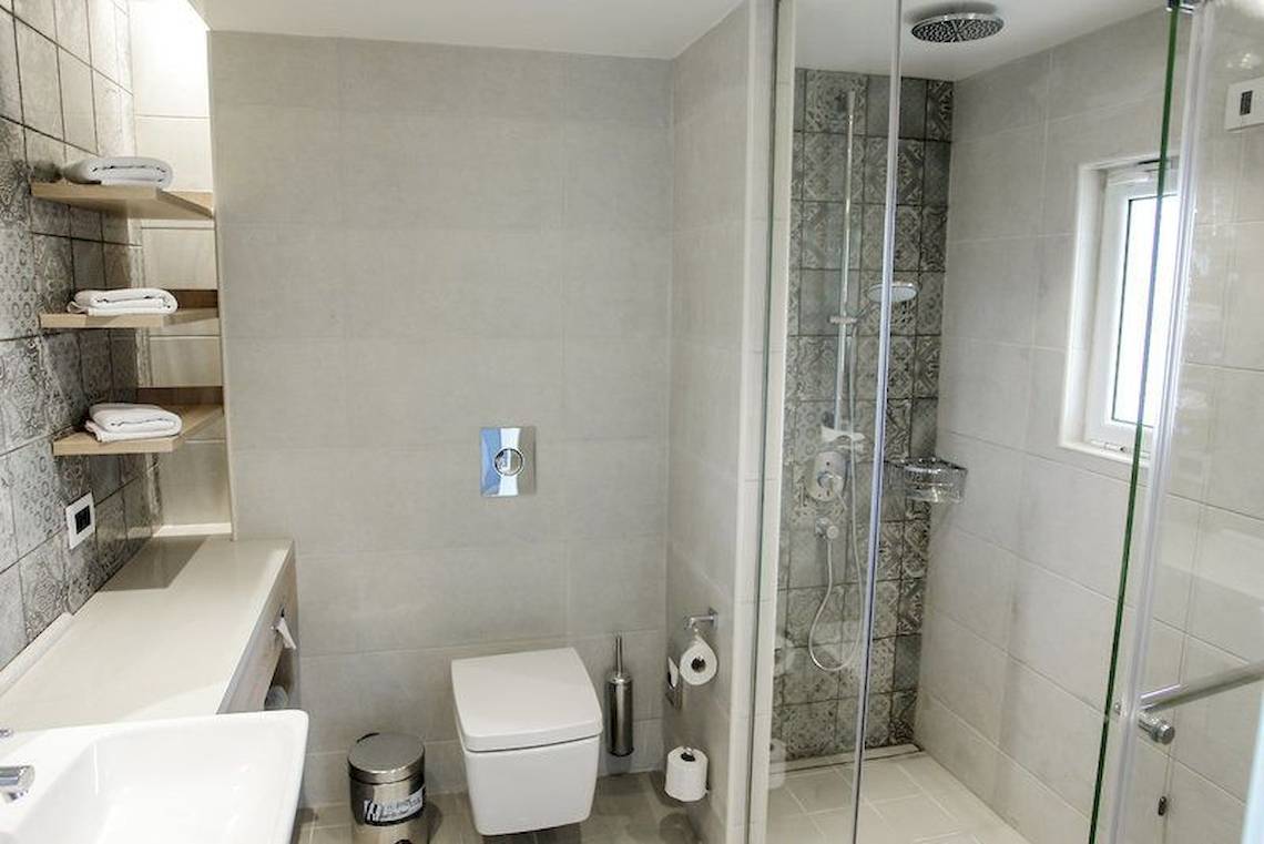 Badezimmer im Robinson Kyllini Beach Hotel mit Dusche, Toilette und Waschbecken.