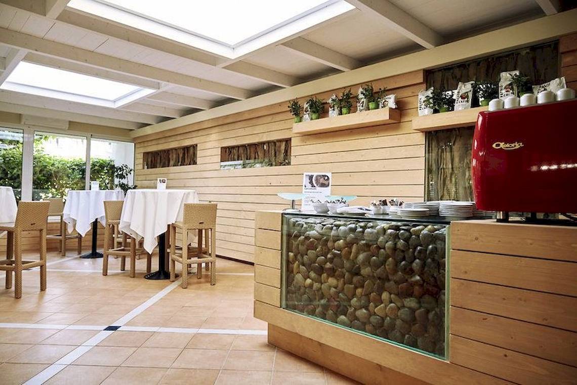 Innenbereich des Robinson Kyllini Beach Hotels mit Holzwänden und einer Steinwand.