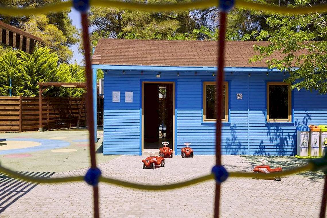 Ein blaues Kinderspielhaus im Freien des Robinson Kyllini Beach Hotels.