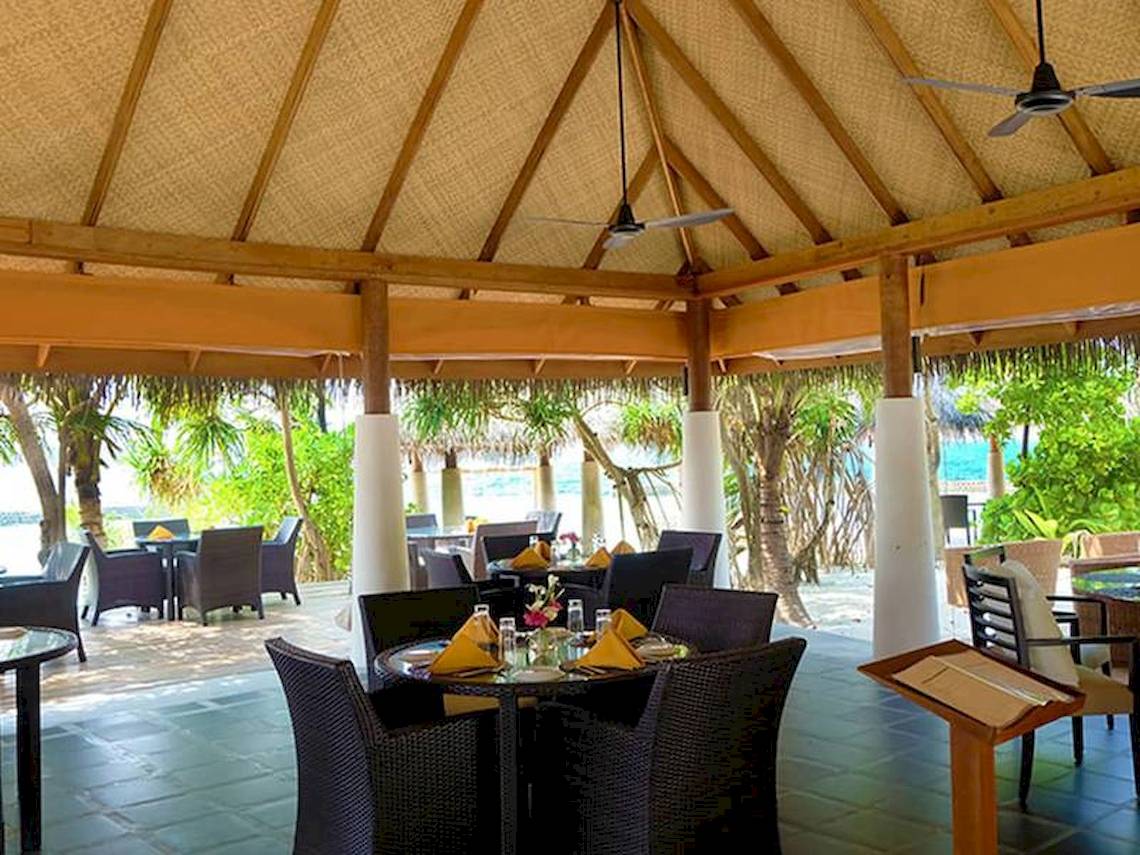 Innenbereich des Amaya Kuda Rah Hotel-Restaurants mit gedeckten Tischen und Stühlen unter einem Pavillon.