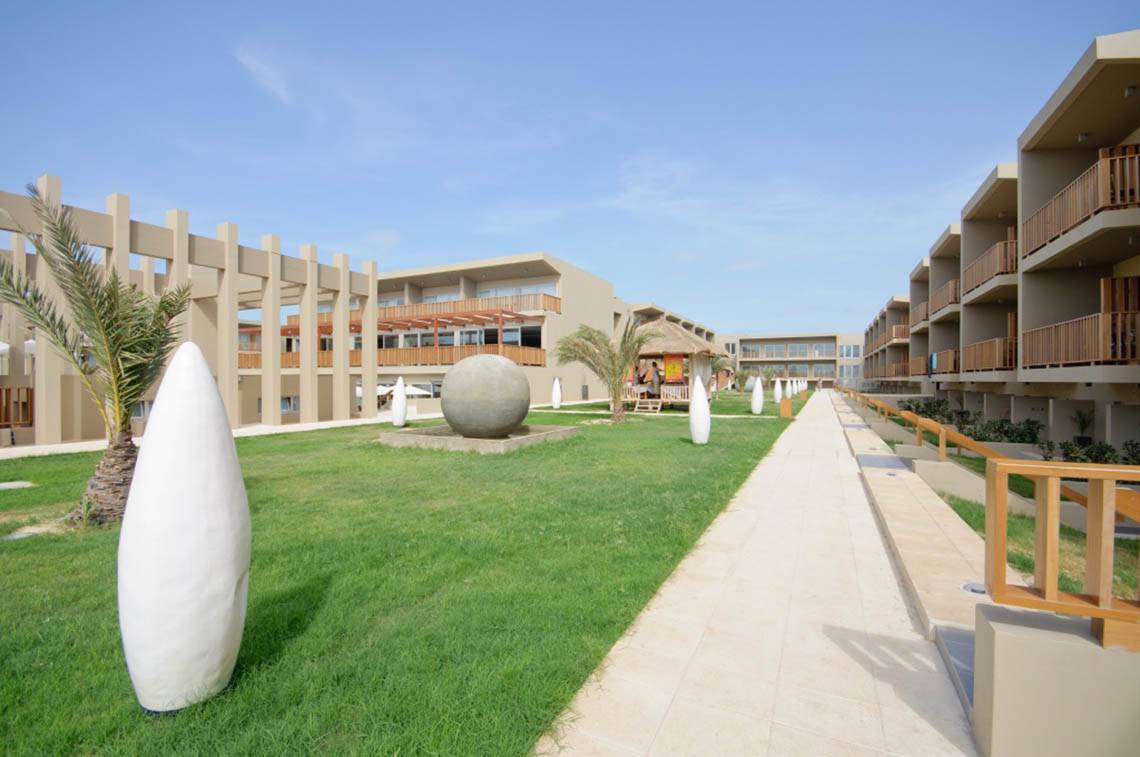 Außenbereich des Oasis Salinas Sea Hotels mit gepflegtem Rasen und weißen Skulpturen.