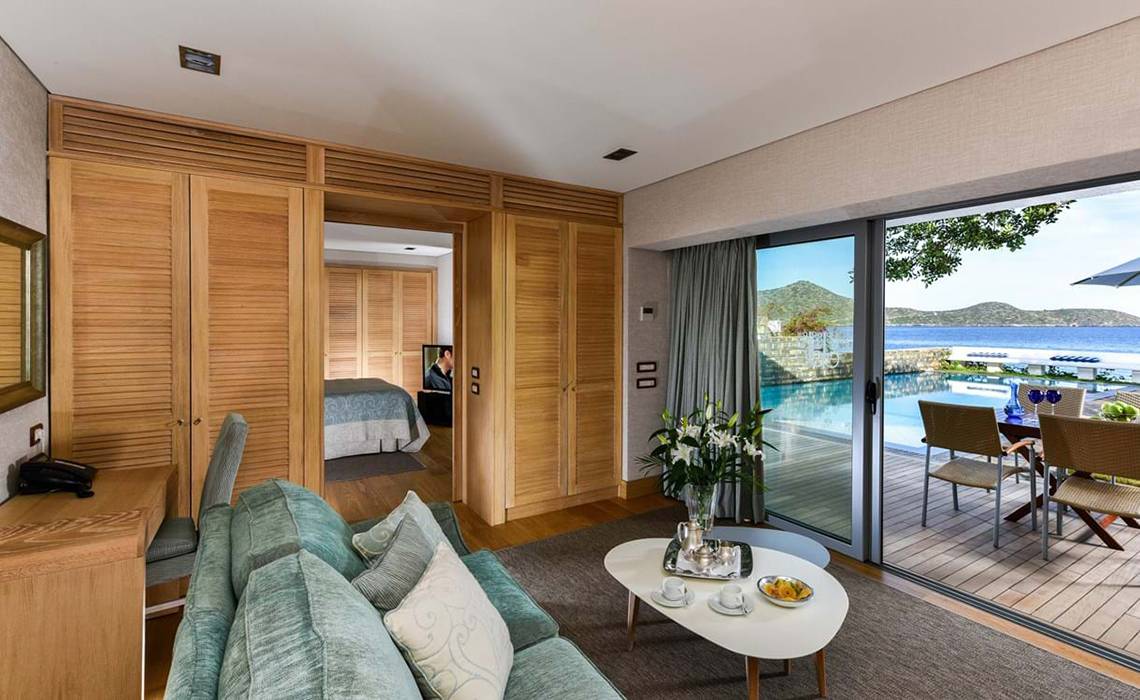 Innenansicht einer Suite im Elounda Beach Hotel & Villas mit Blick auf einen Pool.