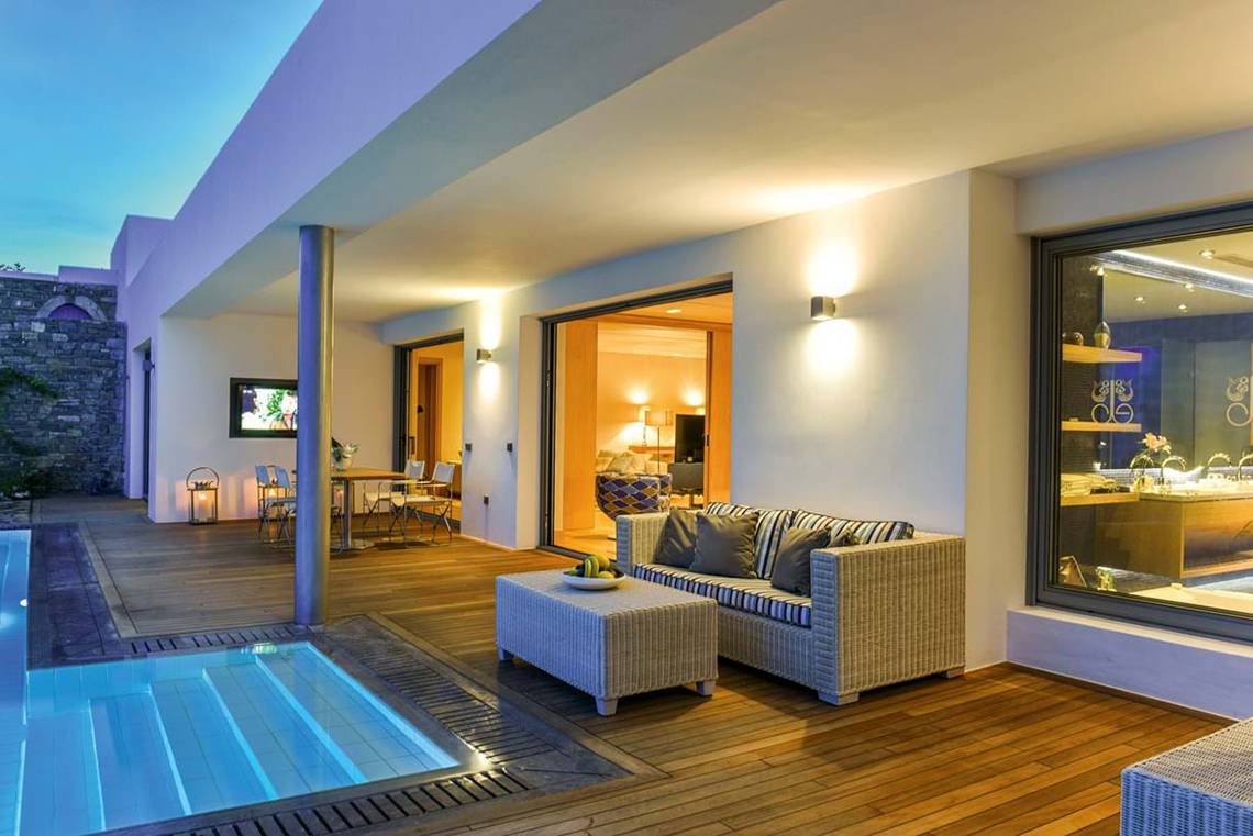 Außenbereich des Elounda Beach Hotel & Villas mit Terrasse und Swimmingpool bei Nacht