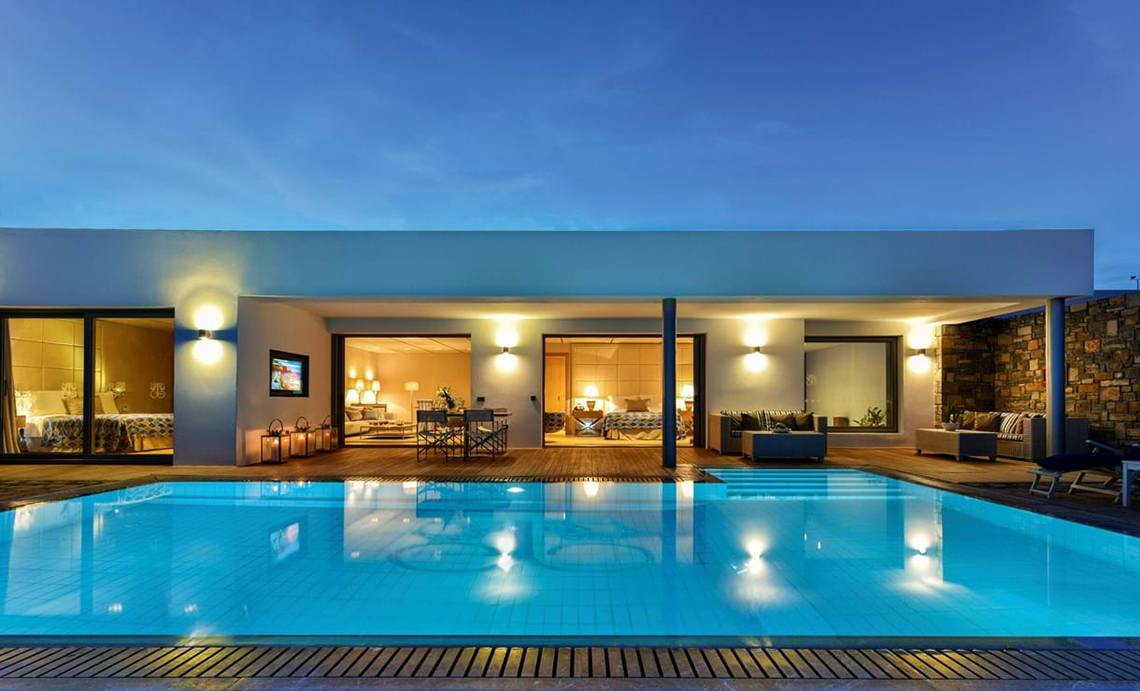 Nachtansicht des Pools des Elounda Beach Hotel & Villas mit beleuchteten Innenräumen