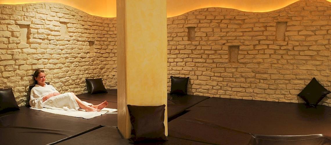 Eine Frau liegt in einem weißen Handtuch auf einer Liege in einem Spa-Bereich des Djerba Resorts.