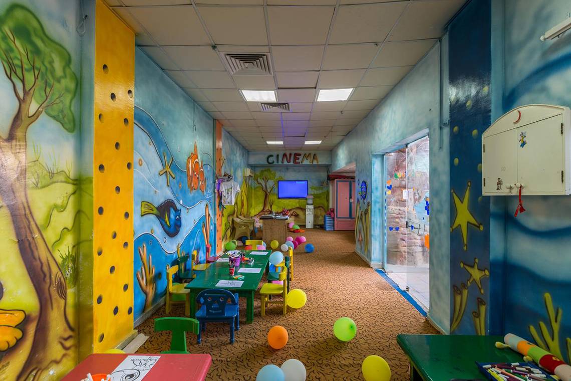 Kinderzimmer im Pickalbatros Aqua Blu Resort - Sharm, mit bunten Wandgemälden, bunten Ballons und Spieltischen.