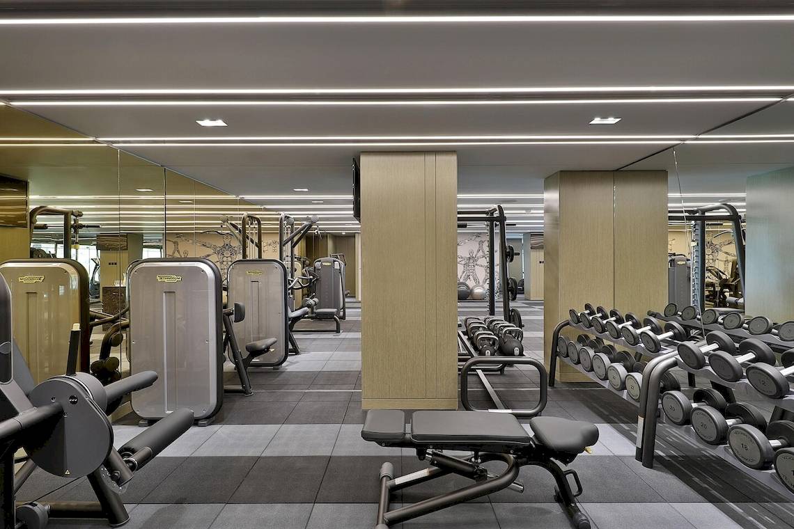 Fitnesscenter im W Muscat Hotel mit verschiedenen Trainingsgeräten und Spiegeln.