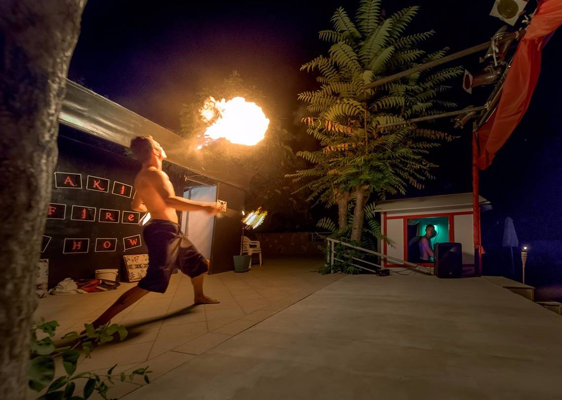 Feuershow im Freien am Olympic Palace Resort mit einem Mann, der Feuer spuckt.
