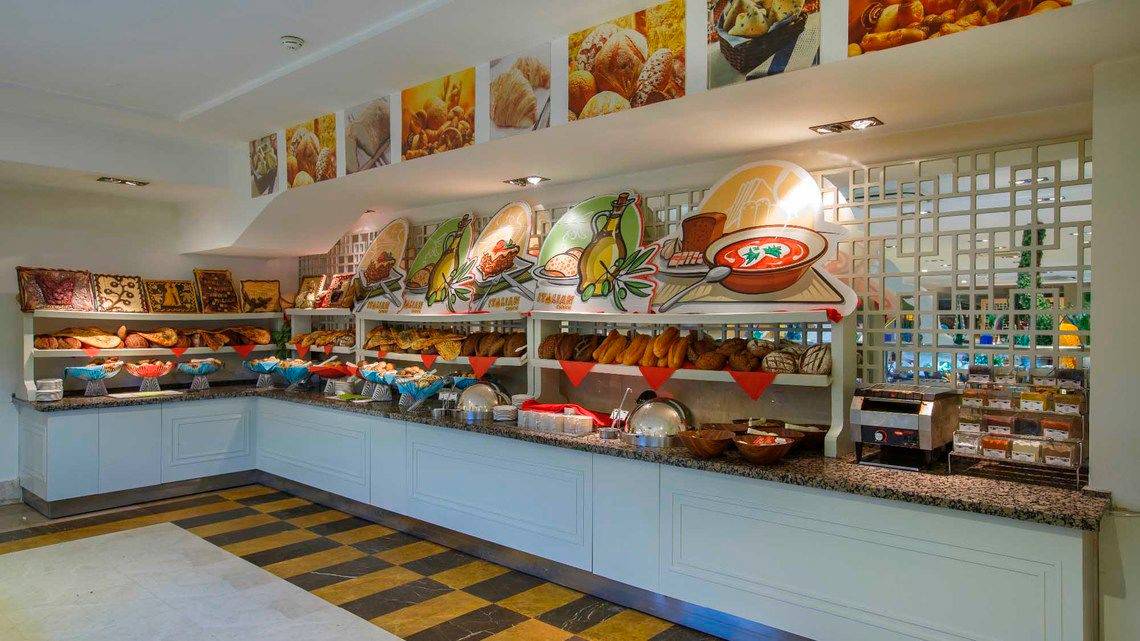 Buffetbereich im Side Crown Palace Hotel mit verschiedenen Brotsorten und Desserts.