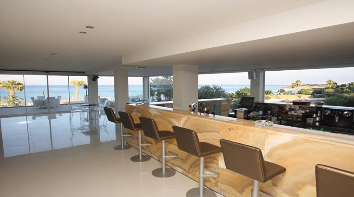 Innenansicht der Bar im Vrissiana Beach Hotel mit Blick auf das Meer.