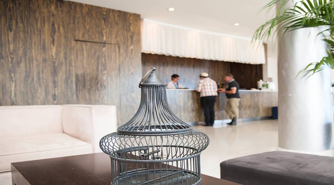 Empfangsbereich des Vrissiana Beach Hotels mit Gästen und Rezeptionisten.