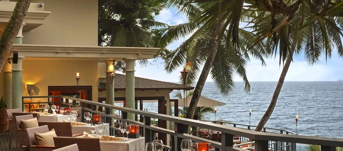 Terrasse des Hilton Seychelles Northolme Resort & Spa mit Blick auf das Meer.