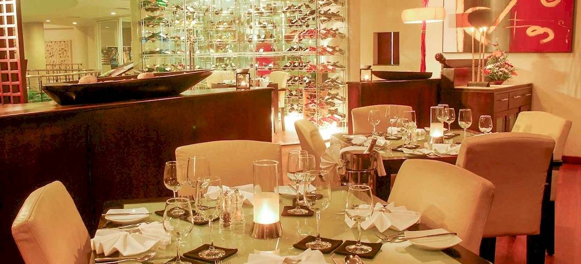 Restaurant des Occidental Eden Beruwala mit gedeckten Tischen und Stühlen.