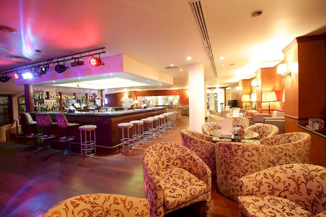 Innenansicht der Bar des Occidental Eden Beruwala mit gepolsterten Stühlen und einer Theke.