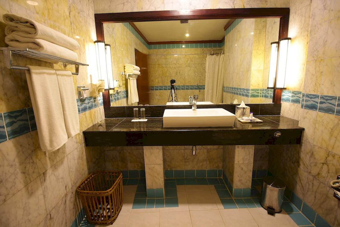 Badezimmer im Occidental Eden Beruwala Hotel mit weißem Waschbecken und Marmorfliesen.