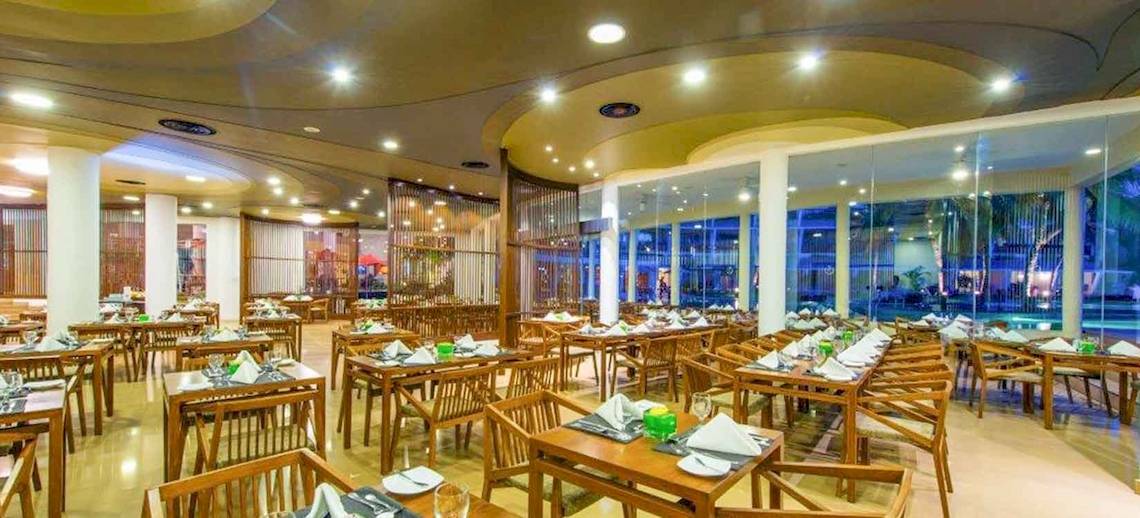 Innenansicht des Restaurants im Occidental Eden Beruwala Hotel mit gedeckten Tischen und Stühlen.