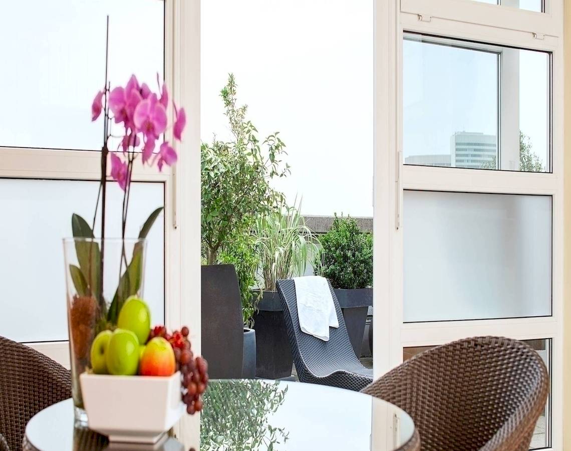NH Hamburg Altona Hotel Innenraum mit Terrassenmöbeln und Obstschüssel