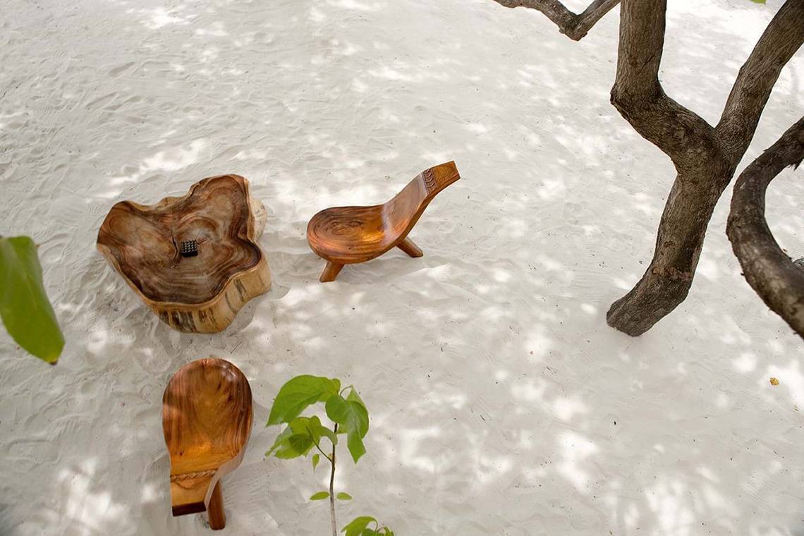 Holzmöbel auf weißem Sand am Constance Moofushi Maldives