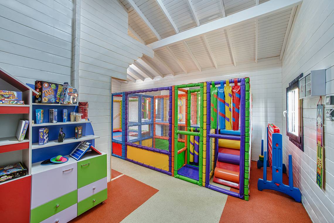 Ein kinderspielzimmer im Aska Lara Resort & Spa mit buntem spielgeraet und regal.