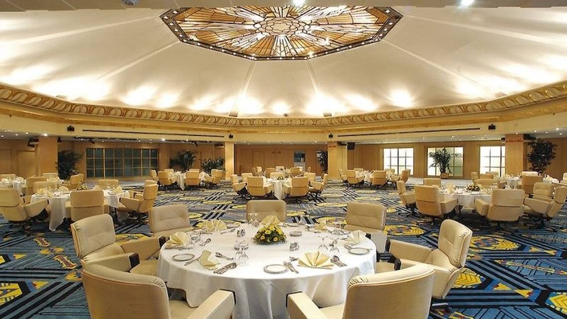 Bankettsaal im Jolie Ville Golf & Resort mit vielen runden Tischen und Stühlen, dekoriert mit Blumen und Geschirr.