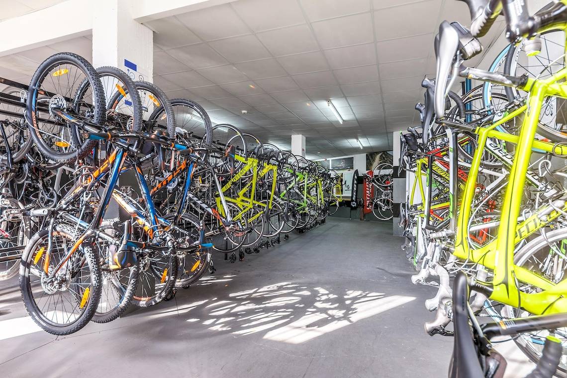 Eine Lagerhalle mit vielen farbigen Fahrrädern, die an der Wand hängen, im Zafiro Tropic Hotel.