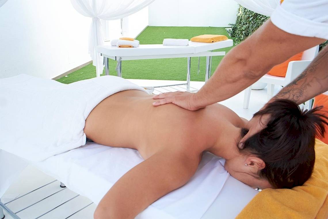 Massage im Hotel Ibiza Sun Apartments: Eine Person erhält eine Rückenmassage auf einem Massagetisch.