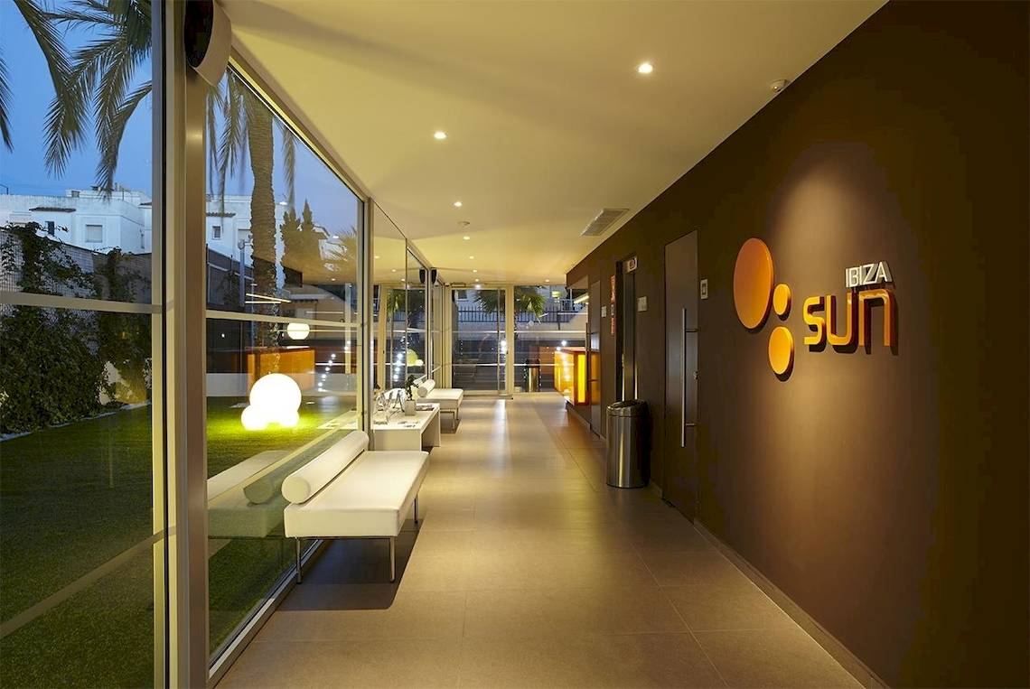 Hotellobby mit weißen Sofas und grünem Rasen im Ibiza Sun Apartments.