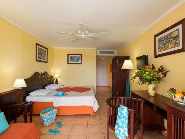 Hotelzimmer im Pierre & Vacances Village Sainte Luce mit Bett, Schreibtisch, Stühlen und Dekor.