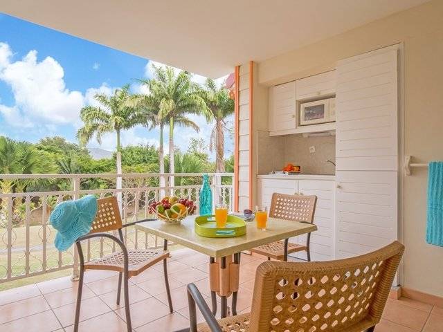 Balkon mit Frühstückstisch und Blick auf Palmen im Pierre & Vacances Village Sainte Luce
