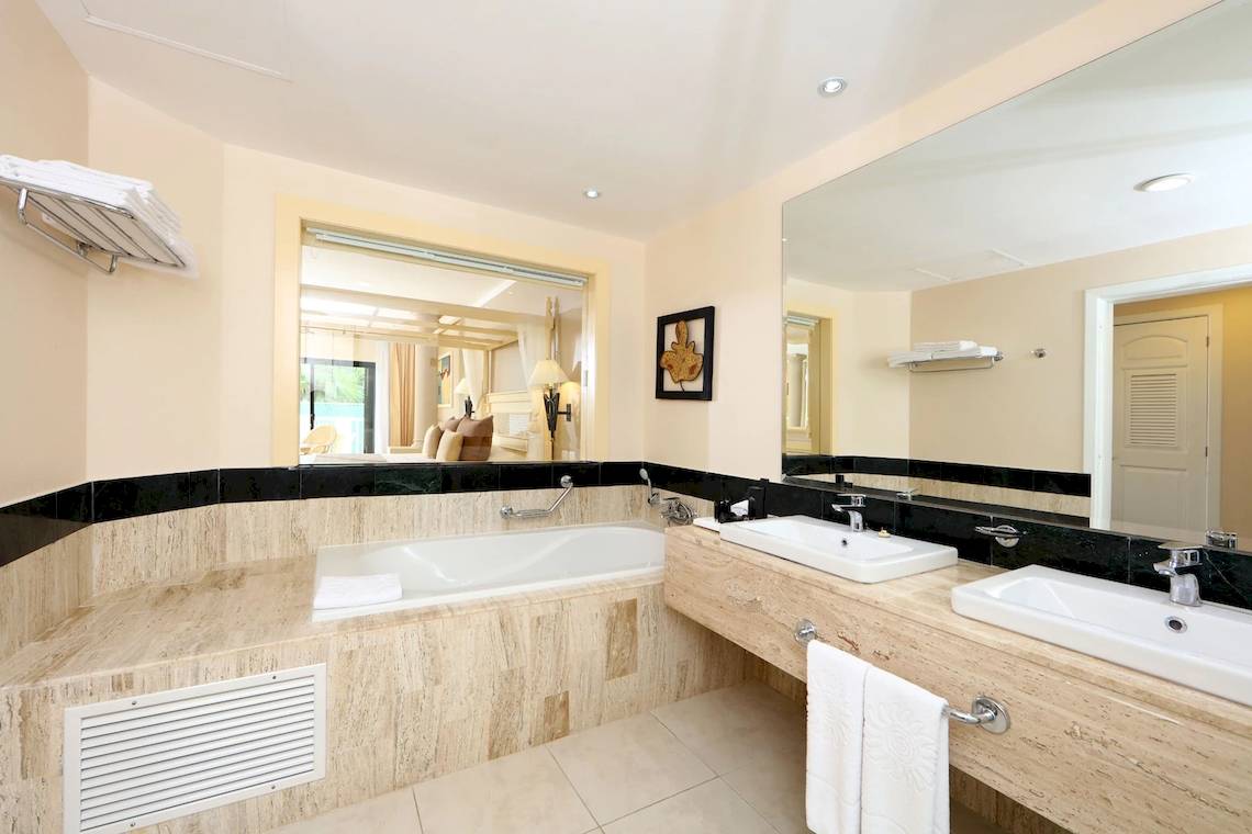Badezimmer mit Doppelwaschbecken, Badewanne und großer Spiegel im Bahia Principe Luxury Akumal