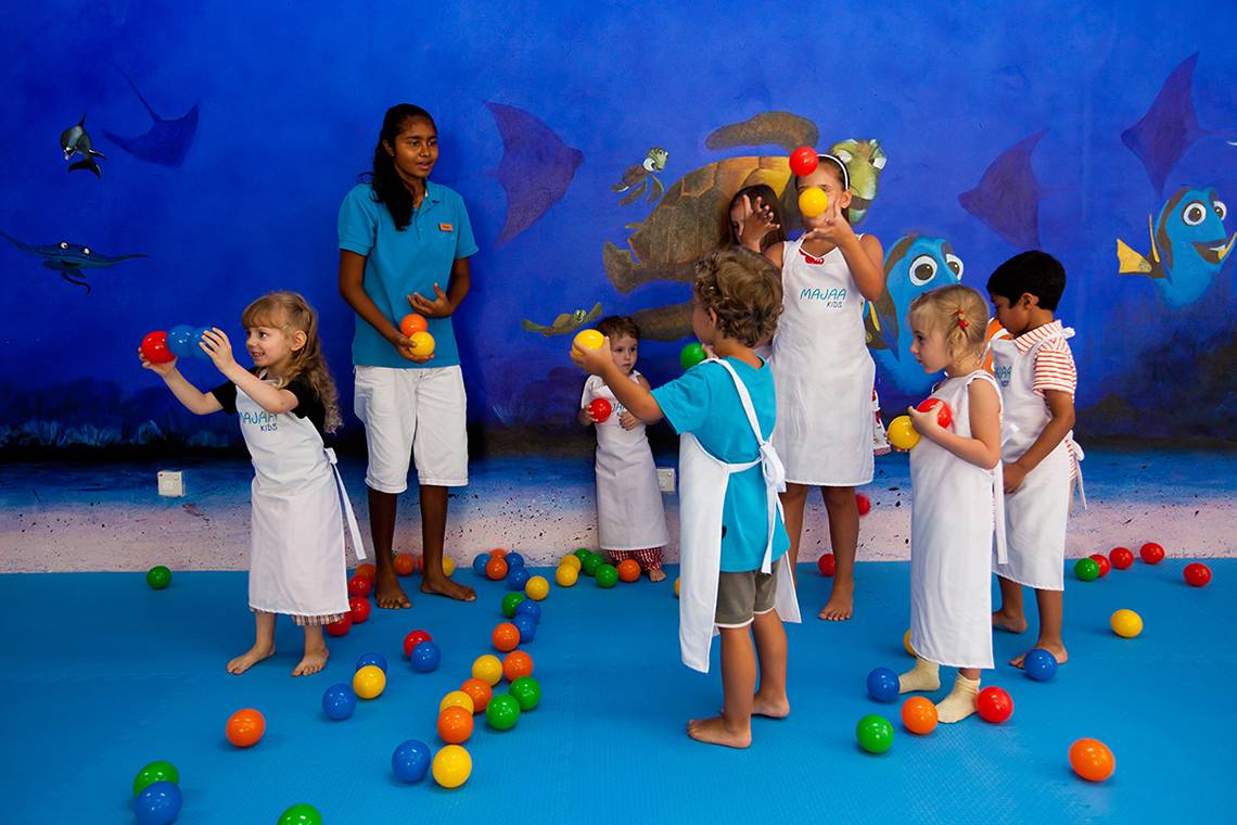 Kinder spielen mit Bällen im Aquarium des Kurumba Maldives.