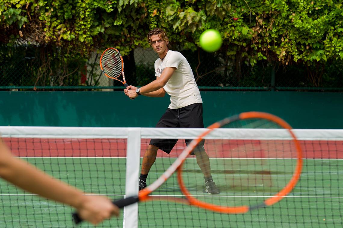 Tennisspieler auf einem Tennisplatz im Kurumba Maldives.