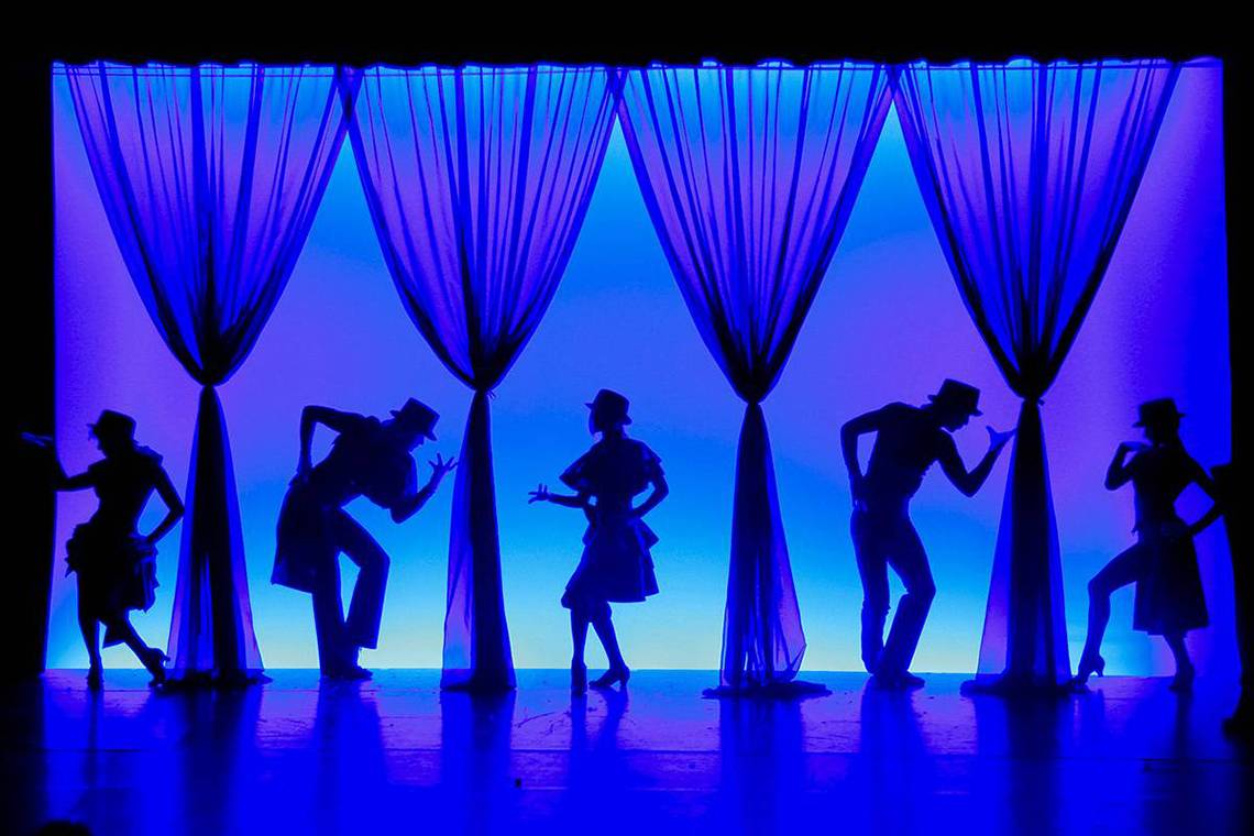 Schattige Tanzszene im Blue Waters Club mit Silhouetten vor blauem Hintergrund.