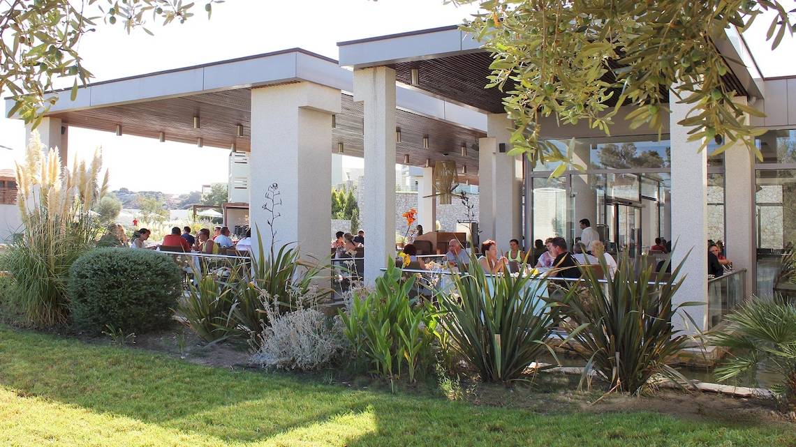 Außenterrasse des Sentido Port Royal Villas & Spa Hotels mit Gästen, die sitzen und essen.