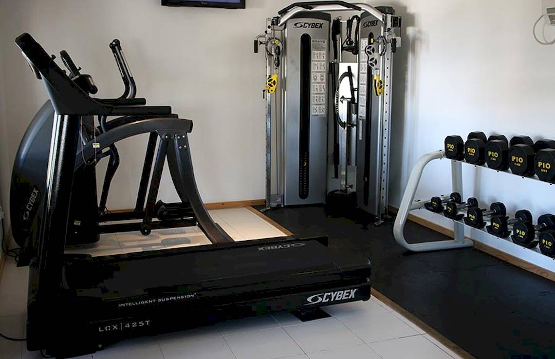Fitnessstudio im Nova Maldives Hotel mit Laufband, Hanteln und Kraftgeräten.