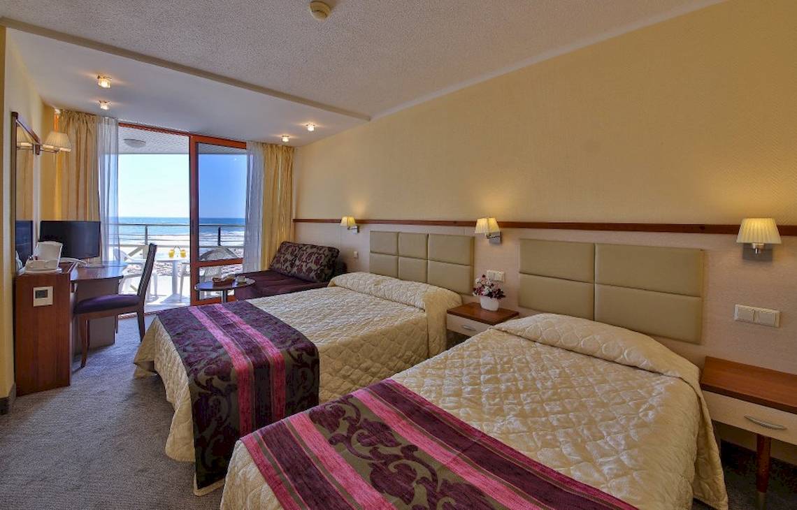 Doppelzimmer im Kaliakra Beach Hotel mit Balkon und Meerblick, zwei Betten, Schreibtisch, Fernseher und Fenster mit Blick auf das Meer.