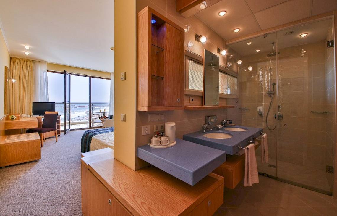 Badezimmer im Kaliakra Beach Hotel mit Blick auf das Meer, zwei Waschbecken und einer Dusche.