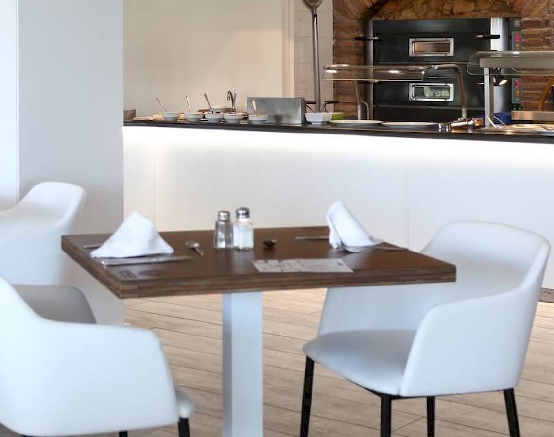 Innenbereich des Sandos El Greco Beach Hotels mit Tisch, Stühlen und Kochbereich
