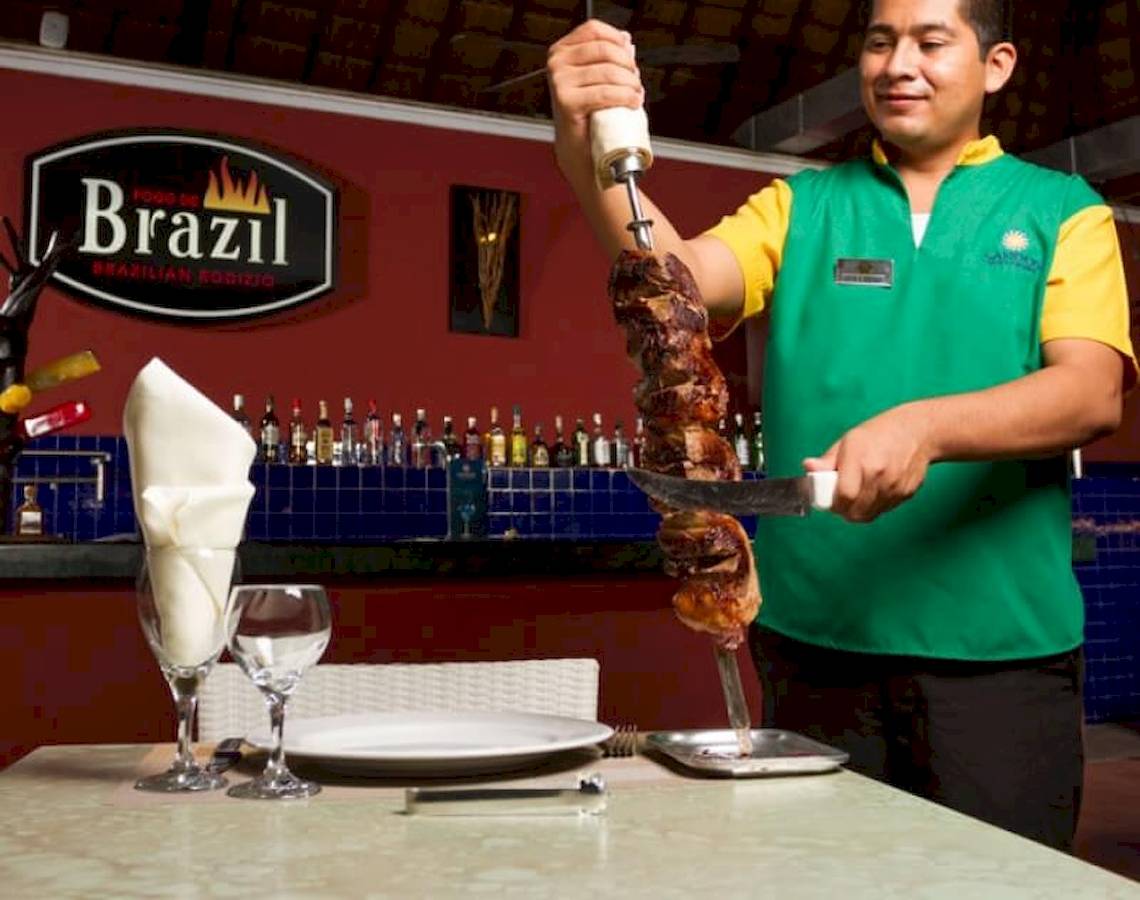 Ein Mitarbeiter schneidet Fleisch im Brazilian Rodizio Restaurant.