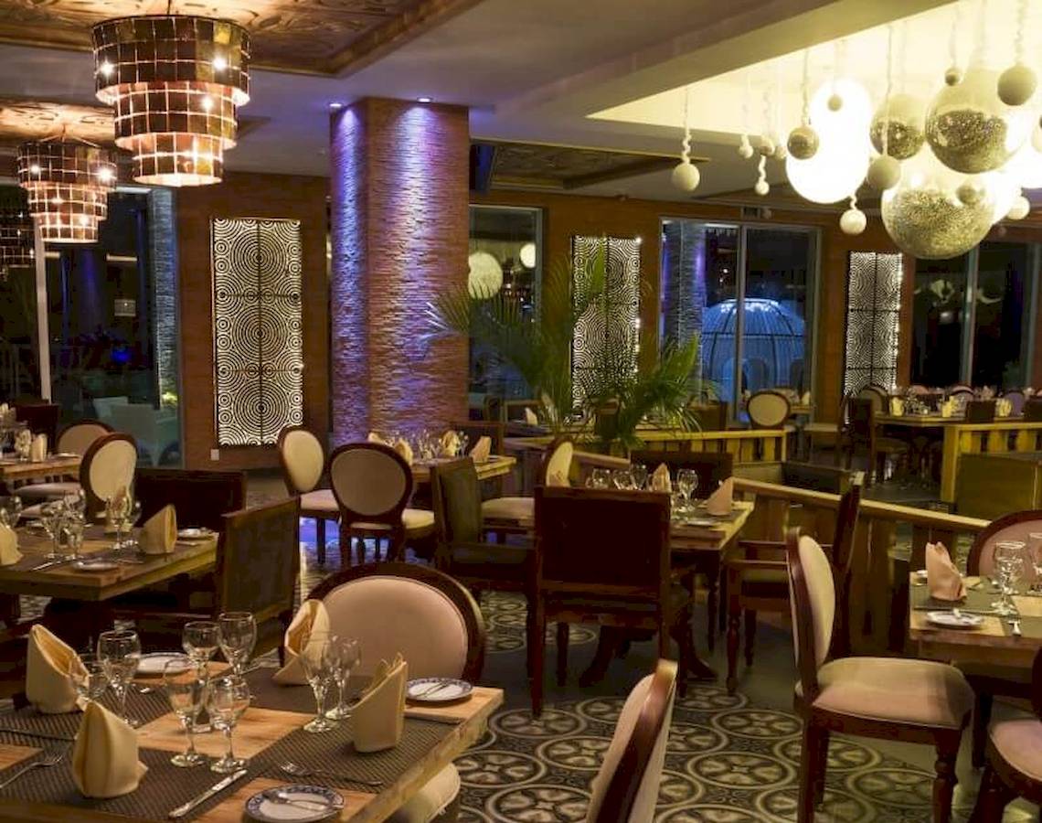 Restaurant des Sandos Caracol Eco Resort mit gedeckten Tischen und dekorativen Lampen.