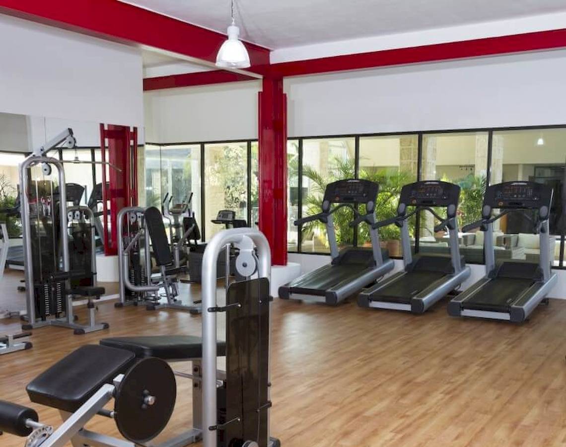 Fitness Center im Sandos Caracol Eco Resort mit Laufbändern und Kraftgeräten.