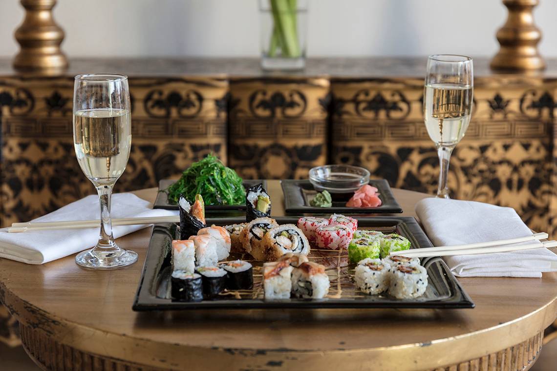 Sushi-Buffet im Mitsis Laguna Resort mit Getränken und Zubehör auf einem Tisch.