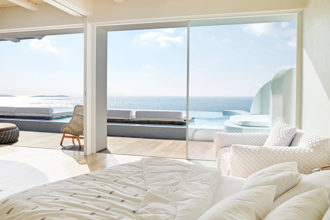 Schlafzimmer des Aeolos Beach Resort auf Korfu mit Blick auf das Meer und eine Terrasse.
