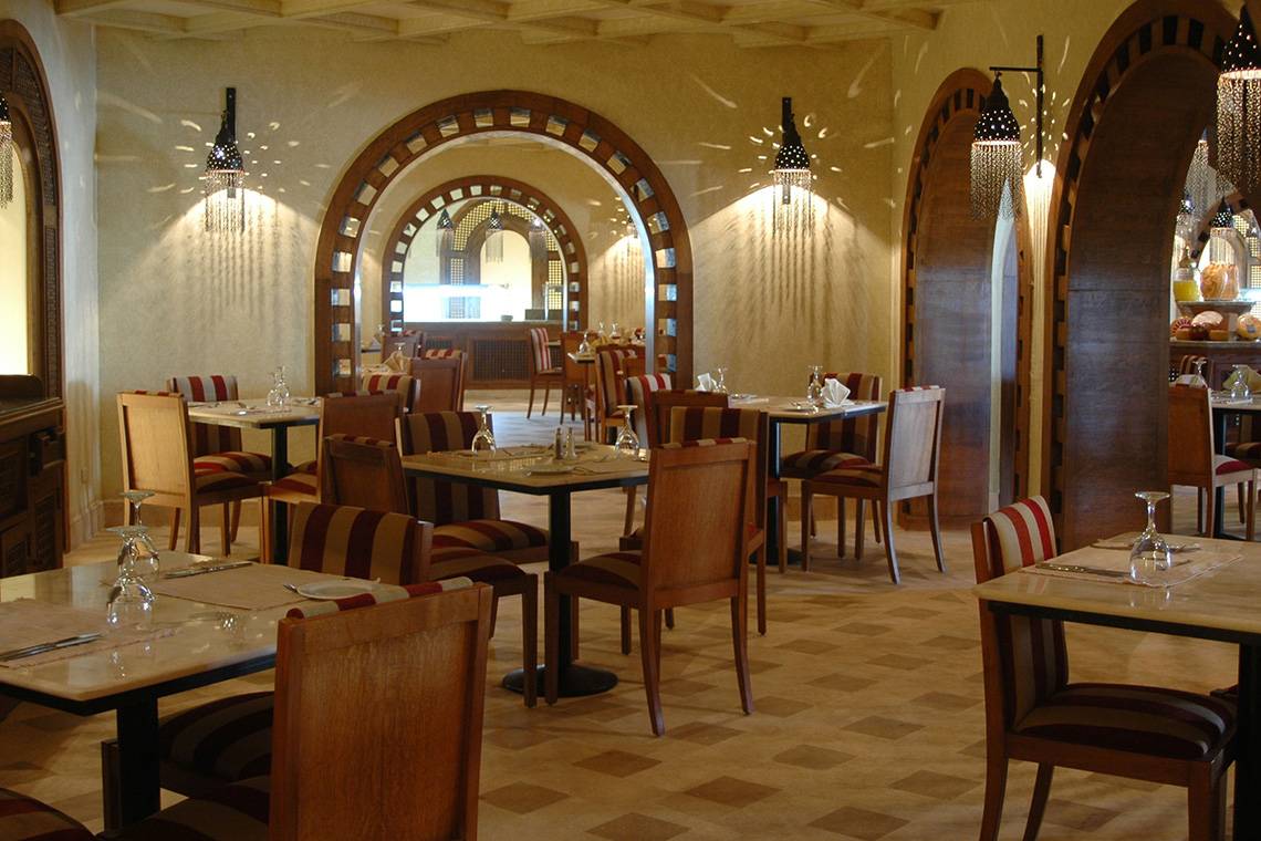 Innenansicht des Ghazala Gardens Restaurants mit geometrischen Bögen und dekorierten Wänden.