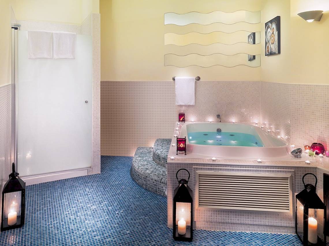 Badezimmer im H10 Estepona Palace mit Badewanne, beleuchtet und bereit für Entspannung.