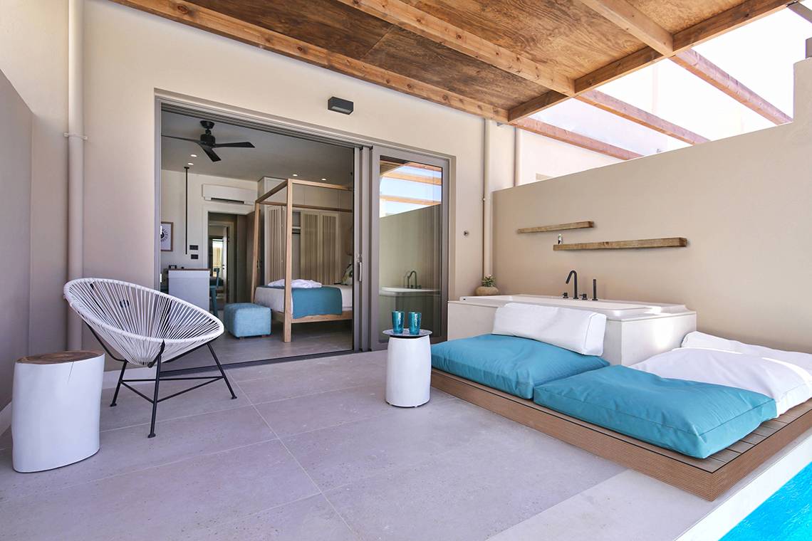 Innenansicht der Suite im Domes Noruz Chania, Autograph Collection mit offenem Schlafzimmer und Badezimmer.